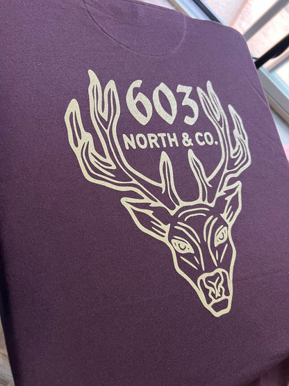 The 603 North deer design is printed on the back of an oxblood hoodie.