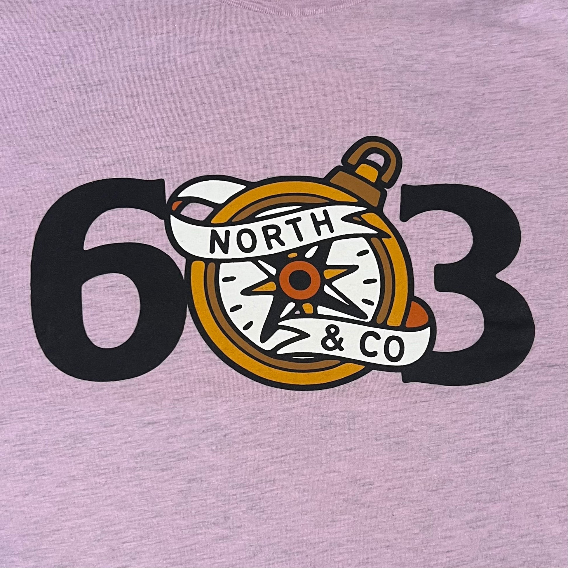 A lilac-colored t-shirt with the 603 compass design printed on the front.